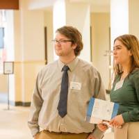 Zane (left) and Aleksandra (right) looking at a poster